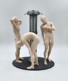 three nude figurines stand on a black base