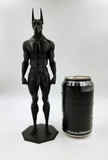 a black statue next to a can of beer