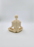 a statue of a man sitting in a yoga position