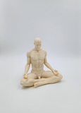 a statue of a man sitting in the middle of a yoga pose